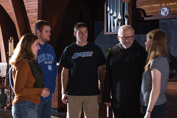 Fr. Lamoureux speaks with students 
[L–R] Emily Capasso ’19, John Killian ’19, Corey Soper ’20, and Maeve McDonald ’21.