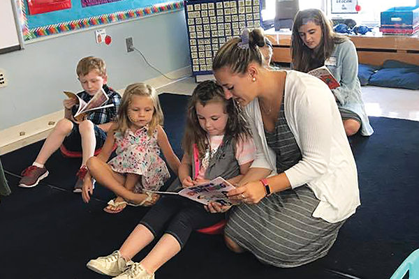 Kristi McCarthy ’19  reads to kindergartners during a classroom visit.