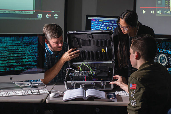 Professor Raymond Albert, Ph.D., demonstrates a hands-on lesson  with students Samuel Malone ʼ20  and Olivia Hulsebosch ʼ20.