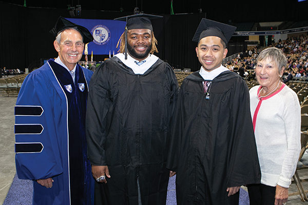 Geoff Smith ’66 and his wife, Erika, with their scholarship recipients, Elijah Riley ’19  and Elijah Reb Mariano ’19,  at Assumption’s 102nd  Commencement ceremony.